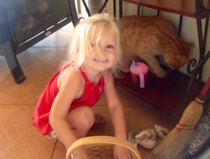 Happy Layna is close to the cat who is trying to act aloof while tracking a lizard.